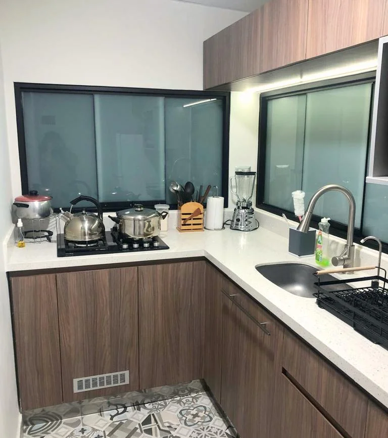Cocina ejecutada (fotografía) — espacio construido con encimera blanca, hornillas y zona de lavado