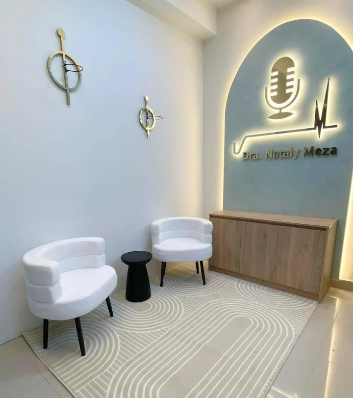 Zona de espera (fotografía) — espacio ejecutado con sillones blancos y logo iluminado